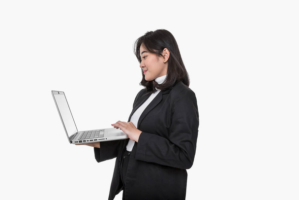 Business woman laptop. Woman with laptop on isolated white background. Girl with laptop in business suit. Business woman uses computer while standing. Business woman in black suit. - Foto, afbeelding