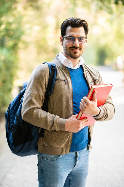 Male student outdoor smiling in a college park looking at camera - Foto, imagen