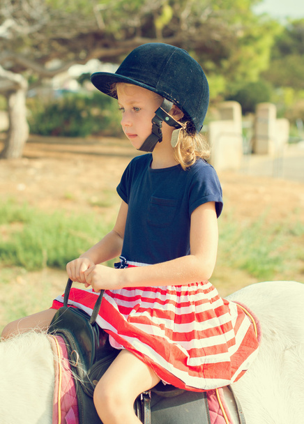 Portrait of little girl riding pony.  - 写真・画像