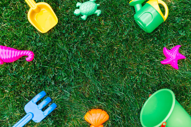 childhood and summer concept - close up of sand toys kit on green lawn or grass - Φωτογραφία, εικόνα