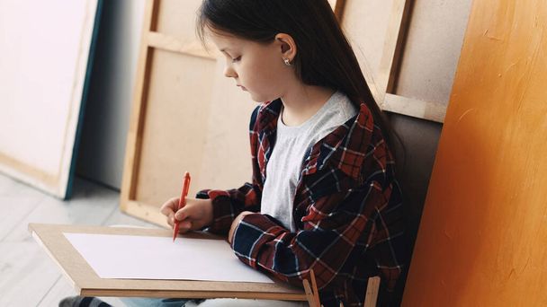 Art hobby. Kids painting. Artistic inspiration. Girl drawing with pencils sitting floor in light room interior. - Foto, imagen