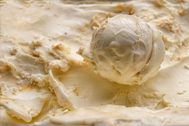 Uma colher de recheio de sorvete com nozes close-up em um fundo de recheio de sorvete - Foto, Imagem
