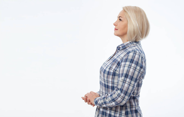 Vonzó középkorú nő hajtogatott karokkal profil elszigetelt fehér háttér - Fotó, kép