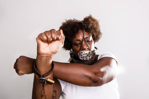 Portrait of a woman trapped with old rusty chains and mask on her face. Slave trade prevention concept. - Foto, afbeelding