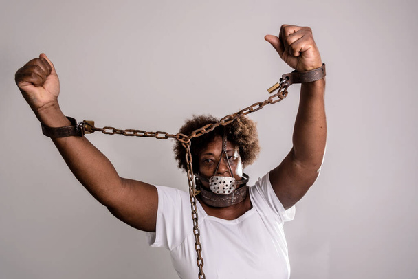 Portrait of a woman trapped with old rusty chains and mask on her face. Slave trade prevention concept. - Foto, Bild