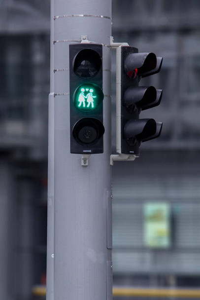 A pedestrian traffic light in support of gay female lesbian couple in Germany. Traffic light showing two women crossing holding their hands. Gay friendly concept. - 写真・画像