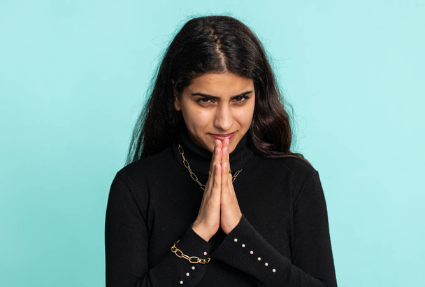 Sneaky cunning indian arabian woman with tricky face gesticulating, scheming evil plan, thinking over devious villain idea, cunning cheats, jokes, pranks. Hindu girl isolated on studio blue background - Photo, Image