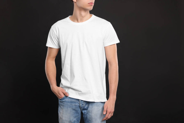 Siyah arka planda beyaz tişört giyen adam, yakın plan. Tasarım için model - Fotoğraf, Görsel