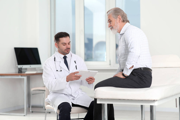 Oudere patiënt heeft een afspraak met arts in kliniek - Foto, afbeelding