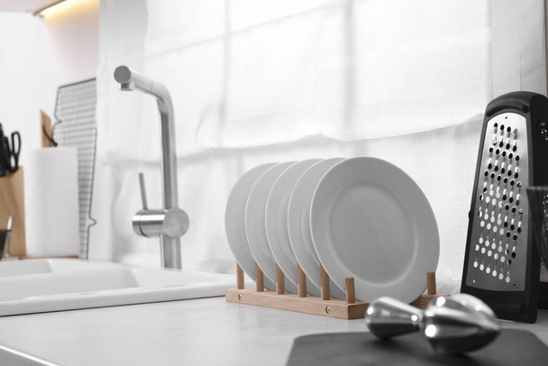 Set of different utensils near sink on countertop in kitchen. Space for text - Foto, afbeelding