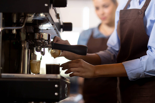 Detailní ruce barista připravuje kávu cappuccino nebo latte při nalévání mléka v šálku kávy v kavárně, close-up mladá asijská žena dělat nápoj na hrnek v kavárně, malý podnik nebo malé a střední podniky. - Fotografie, Obrázek