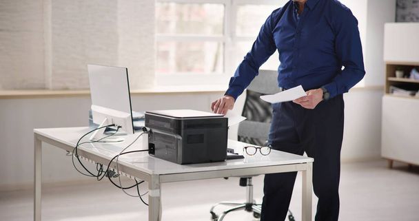 Man Using Photocopy Machine In Office. Printer And Copier - Foto, Bild