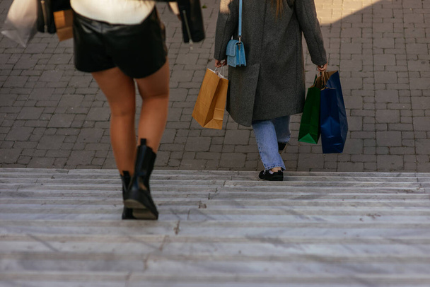 Due ragazze con le borse della spesa che escono dal centro commerciale. Scendere di sotto - Foto, immagini