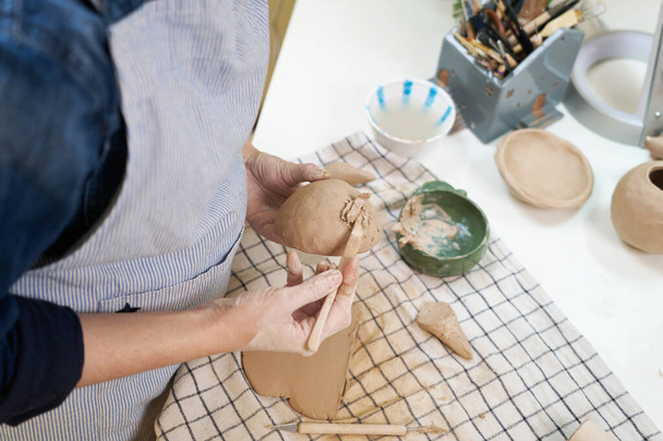 woman forming clay pot shape by hands, closeup in artistic studio. - 写真・画像