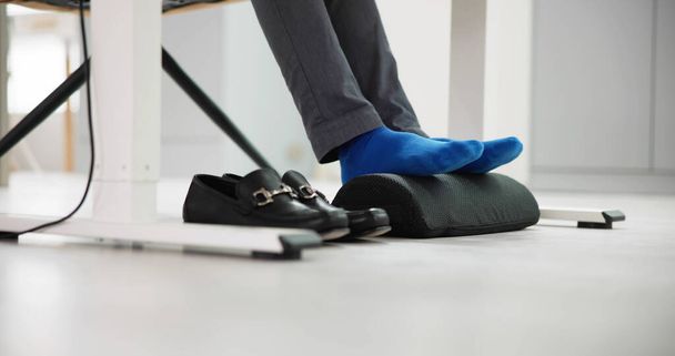 Man Using Footrest To Reduce Back Strain And Feet Fatigue - Fotoğraf, Görsel