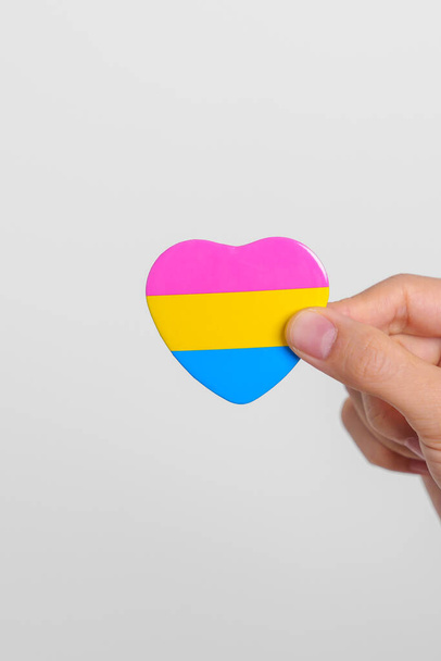 Dia do Orgulho Pansexual e conceito de mês de orgulho LGBT. mão segurando rosa, amarelo e azul forma do coração para lésbicas, gay, bissexual, transexual, queer e pansexual comunidade - Foto, Imagem
