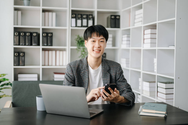 Young businessman working at office with laptop and phone - Photo, image