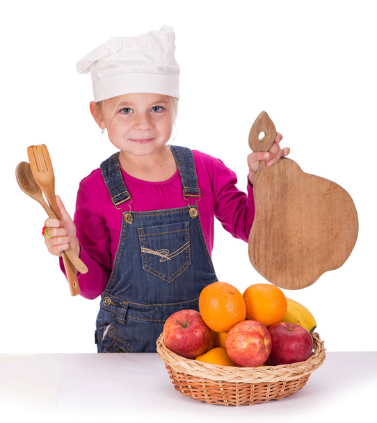 Close-up portrait of a little girl holding fruits and kitchen appliances - Fotó, kép