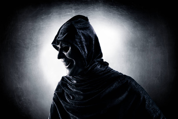 Scary figure with hooded cloak in the dark - Фото, зображення