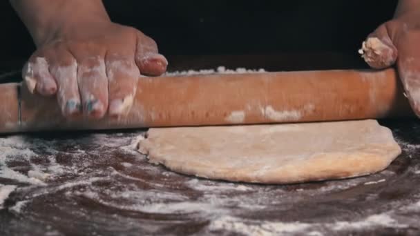 Rolling out the dough with a rolling pin by female hands close-up. Homemade flour cakes. Knead the sticky dough with your hands in slow mo. Organic fresh bread. Baker bakes food at the bakery. - Footage, Video