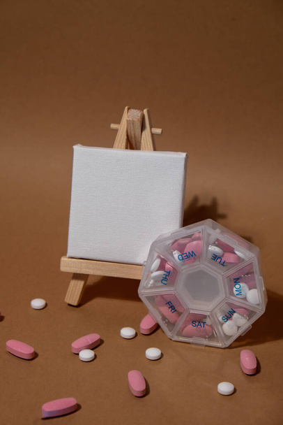 Closeup of medical pill box with doses of tablets for daily take medicine with white pink drugs and capsules with paper note Copy space for your text template mock up. Daily vitamins at home - Foto, immagini