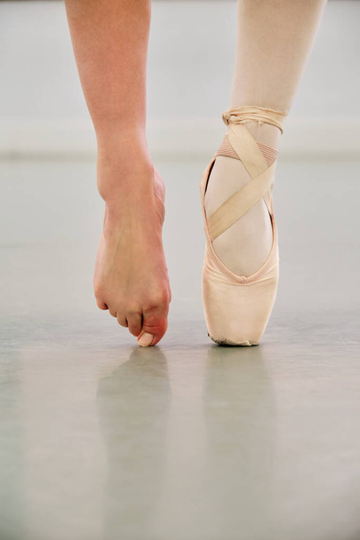 Cropped shot of a young ballerina wearing a pointe shoe on one foot and nothing on the other. - Zdjęcie, obraz