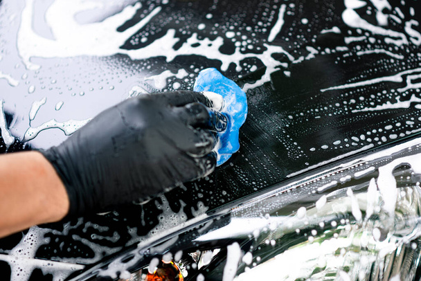 Washing the black car. Car cleaning and car care concept. - Photo, Image