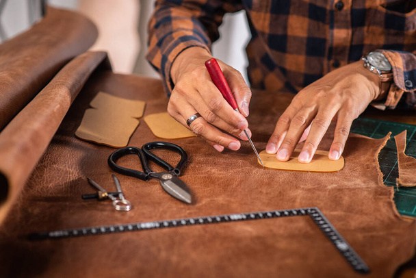 The man working with genuine leather in workshop. - Zdjęcie, obraz