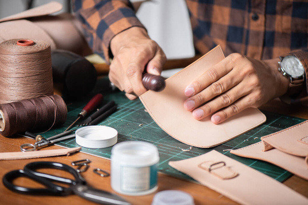 The man working with genuine leather in workshop. - Zdjęcie, obraz