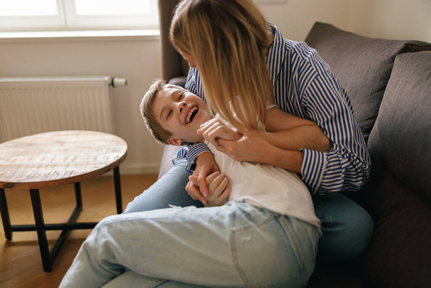 Happy mother and little son enjoying leisure time together at home. Motherhood concept - Valokuva, kuva