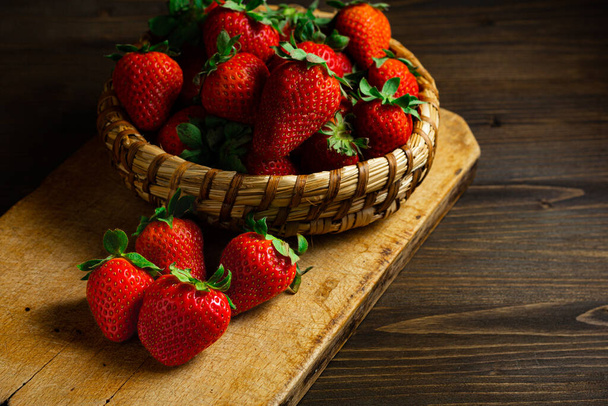 Φράουλες σε ξύλινο μπολ. Φρέσκες ωραίες φράουλες στο ξύλινο τραπέζι. Φράουλα χυμό. Ρουστίκ στυλ - Φωτογραφία, εικόνα