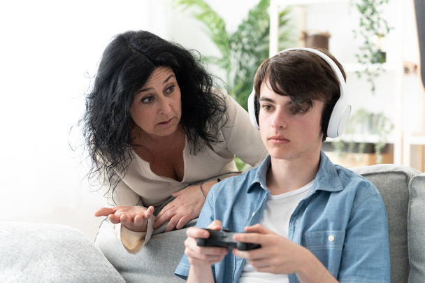 Mother trying to talk teenager son and the boy ignoring her. Adolescence communication problems concept - Photo, Image