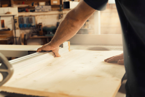 鋭い焦点で、木工職人の手は、彼のワークショップで手作りの家具のコンポーネントを慎重に配置、挿入、および修正します。彼は技術と決意を持って行動する前に考えている。背景はbl - 写真・画像