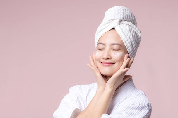 Asian young woman applying facial skincare face cream, cosmetic moisturiser on healthy natural skin make up face. Portrait glowing smile girl person model with care beauty product, spa, cosmetology. - Fotografie, Obrázek