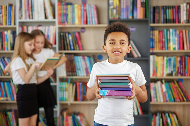 Концепція навчання, повернення до школи та освіти. Дитячий школяр читає книгу в бібліотеці або книгарні
. - Фото, зображення