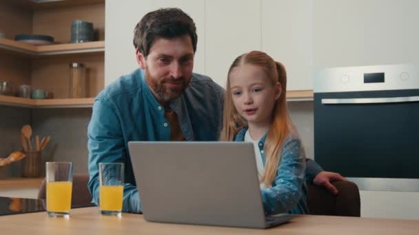 Szülői felügyelet kaukázusi apa tanítás kis lánya segítségével laptop app otthon konyha apa magyarázza számítógépes szoftver segít az e-learning online böngészés gyerek lány boldog család gyümölcslé - Felvétel, videó