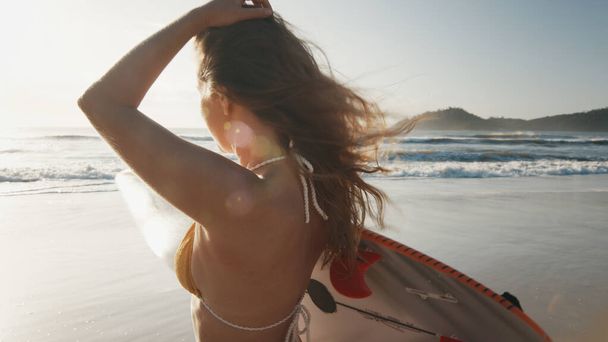 Nainen surffaaja kävelee surffilauta trooppisella rannalla - Valokuva, kuva