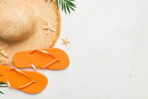 Summer travel concept. Flip flops, summer hat and starfish on white. Top view on colored background. - Valokuva, kuva