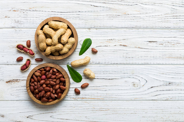 Fresh healthy peanuts in bowl on colored table background. Top view Healthy eating bertholletia concept. Super foods. - Foto, afbeelding