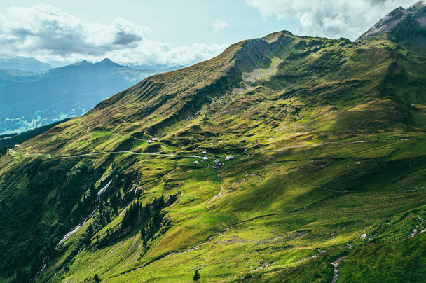Летний горный пейзаж с зеленой травой и горными вершинами. Альпы Швейцарии - Фото, изображение