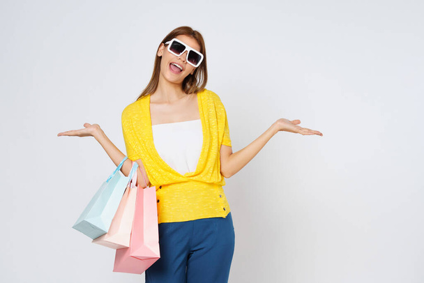 Aufregende junge Frau hält Einkaufstüten isoliert auf weißem Hintergrund. - Foto, Bild