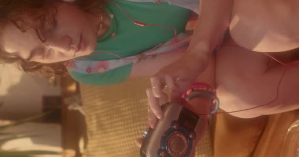 Vertical de jengibre chica caucásica en auriculares sobre la oreja, escuchando música a través de reproductor de cinta en casa - Metraje, vídeo