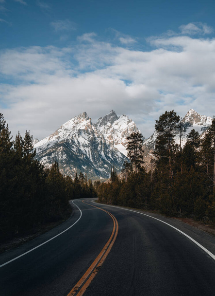 A winding paved road to Grand Targhee ski area looks up toward the summit of the Grand Teton in Wyoming - Foto, Imagem
