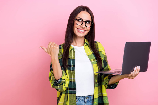Portrait of pleasant smart person brunette hair yellow jacket look directing empty space hold laptop isolated on pink color background. - Φωτογραφία, εικόνα