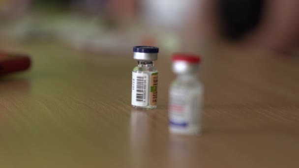 Flacone con vaccino in flaconcino trasparente sul tavolo in laboratorio - Filmati, video