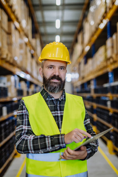 Portrait of a warehouse worker or a supervisor with digital tablet. - Photo, Image