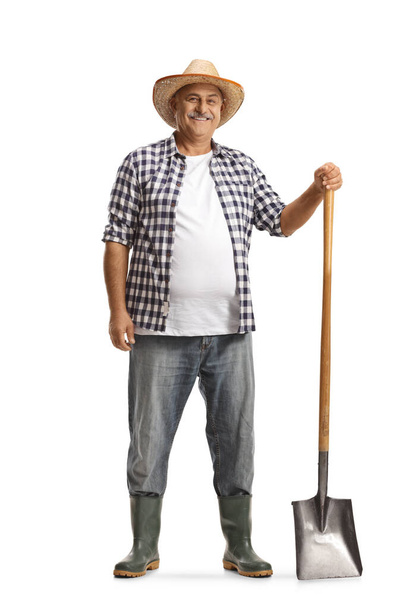 Full length portrait of a happy mature farmer with a shovel isolated on white background - Foto, Imagem