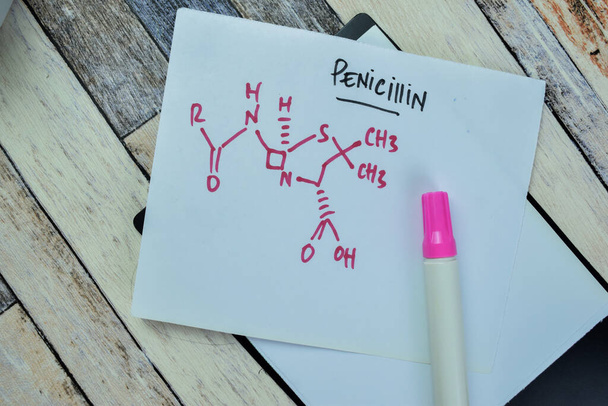 Концепція хімічного молекулярного синтезу гормону пеніцилін написаний на липких нотатках, ізольованих на дерев "яній таблиці.. - Фото, зображення
