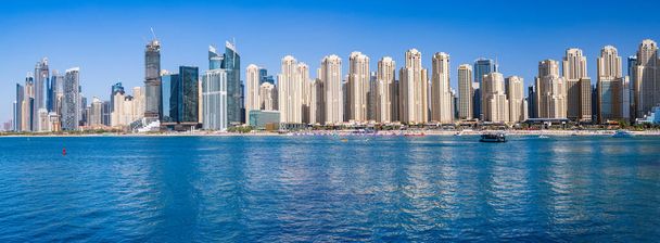 Широкая панорама новых квартир среди отелей на берегу океана в районе Jumeirah Beach Residence Дубая - Фото, изображение
