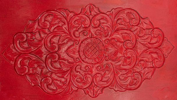 Nahaufnahme Textur aus leuchtend rot gebeiztem Holz Tür mit geschnitzten Blume kompliziertes Design in Bali - Foto, Bild